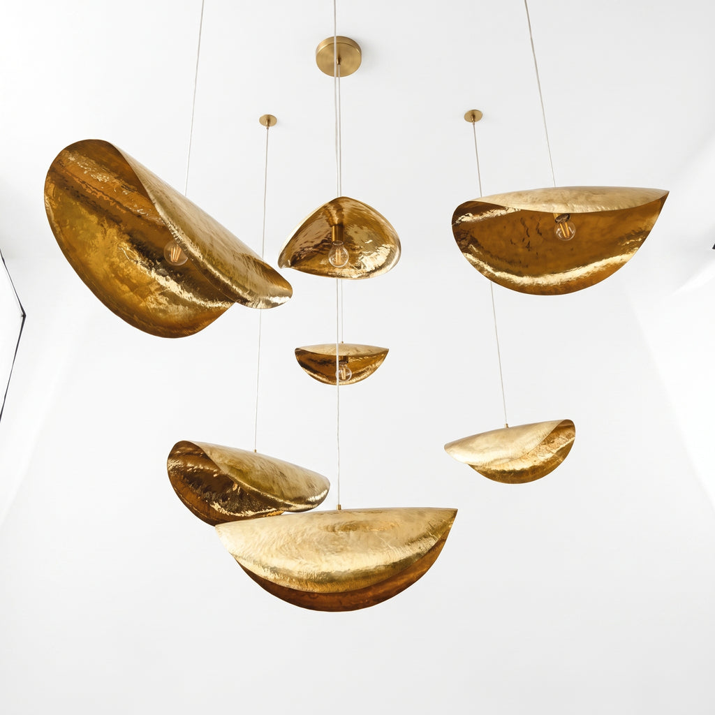 Front view of the sculptural brass chandelier with multiple hanging shades