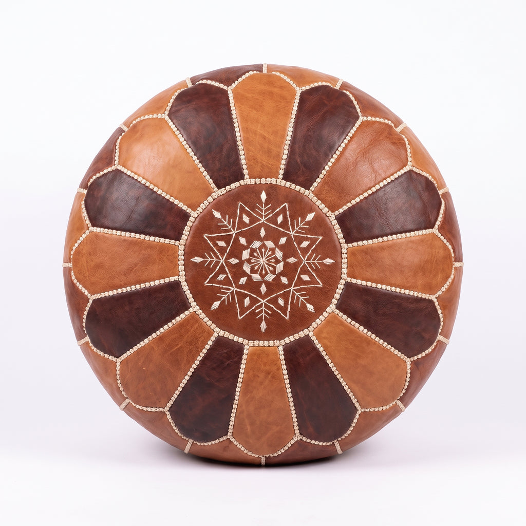 Top view of a two-tone brown leather pouf with alternating panels and central star embroidery