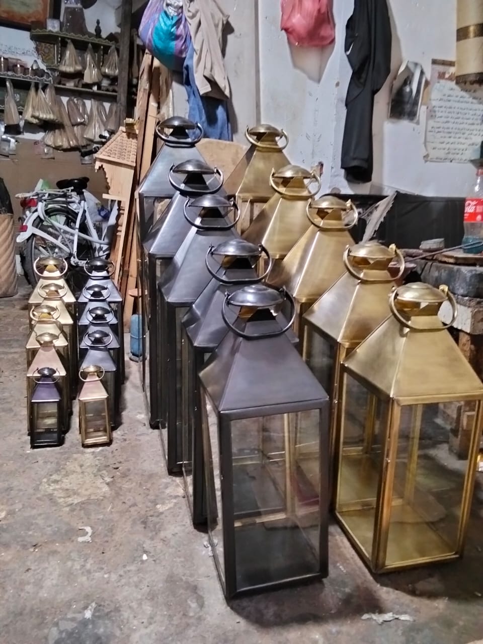 Rows of black and brass metal lanterns displayed in a craft workshop
