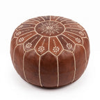 Brown Moroccan leather pouf with scalloped floral embroidery on a white background