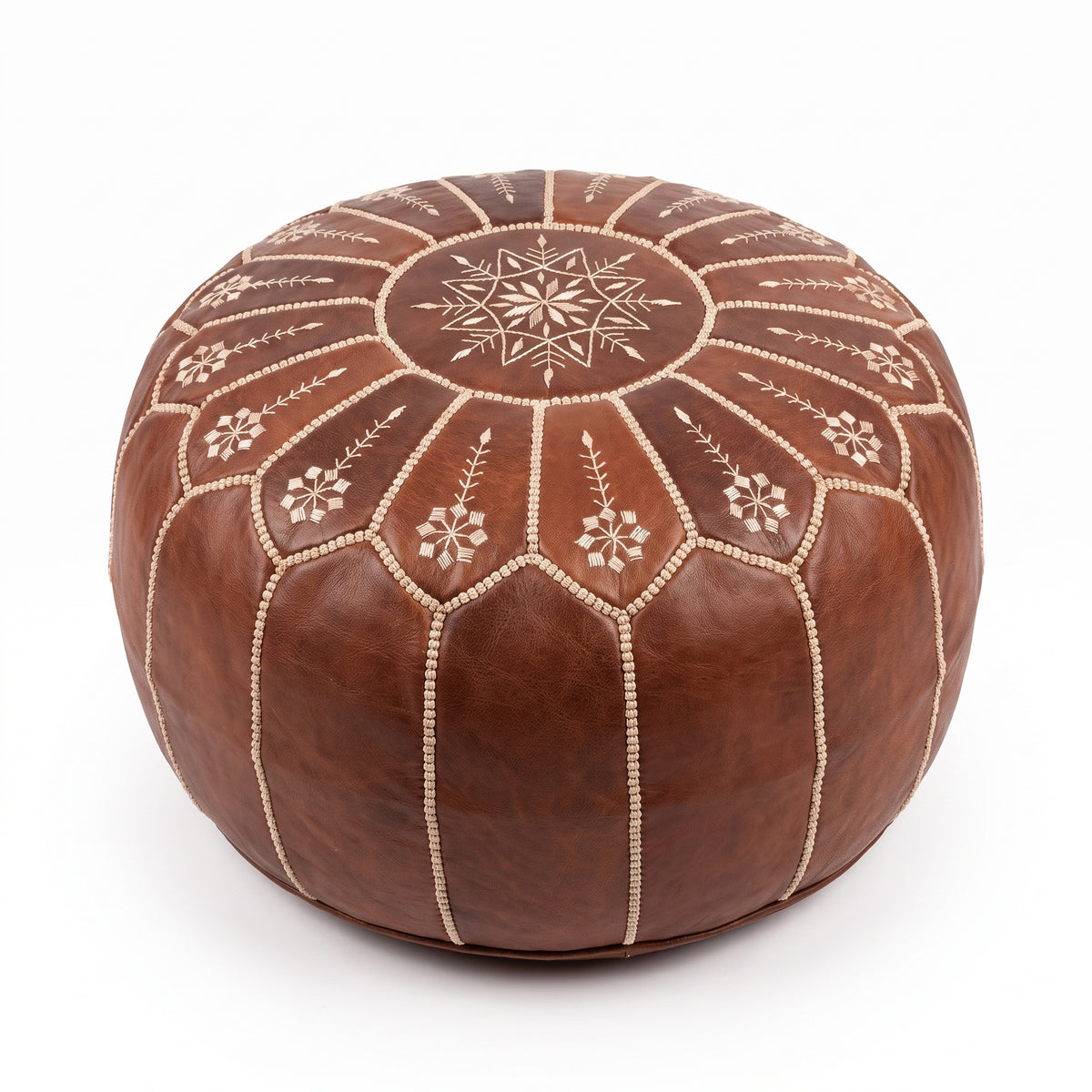 Brown Moroccan leather pouf with scalloped floral embroidery on a white background