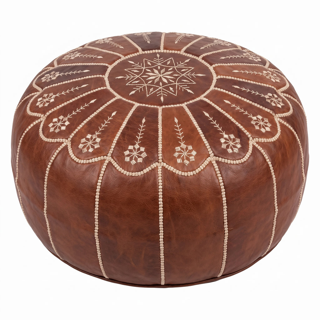 Angled view of a brown leather pouf showing its embroidered floral top