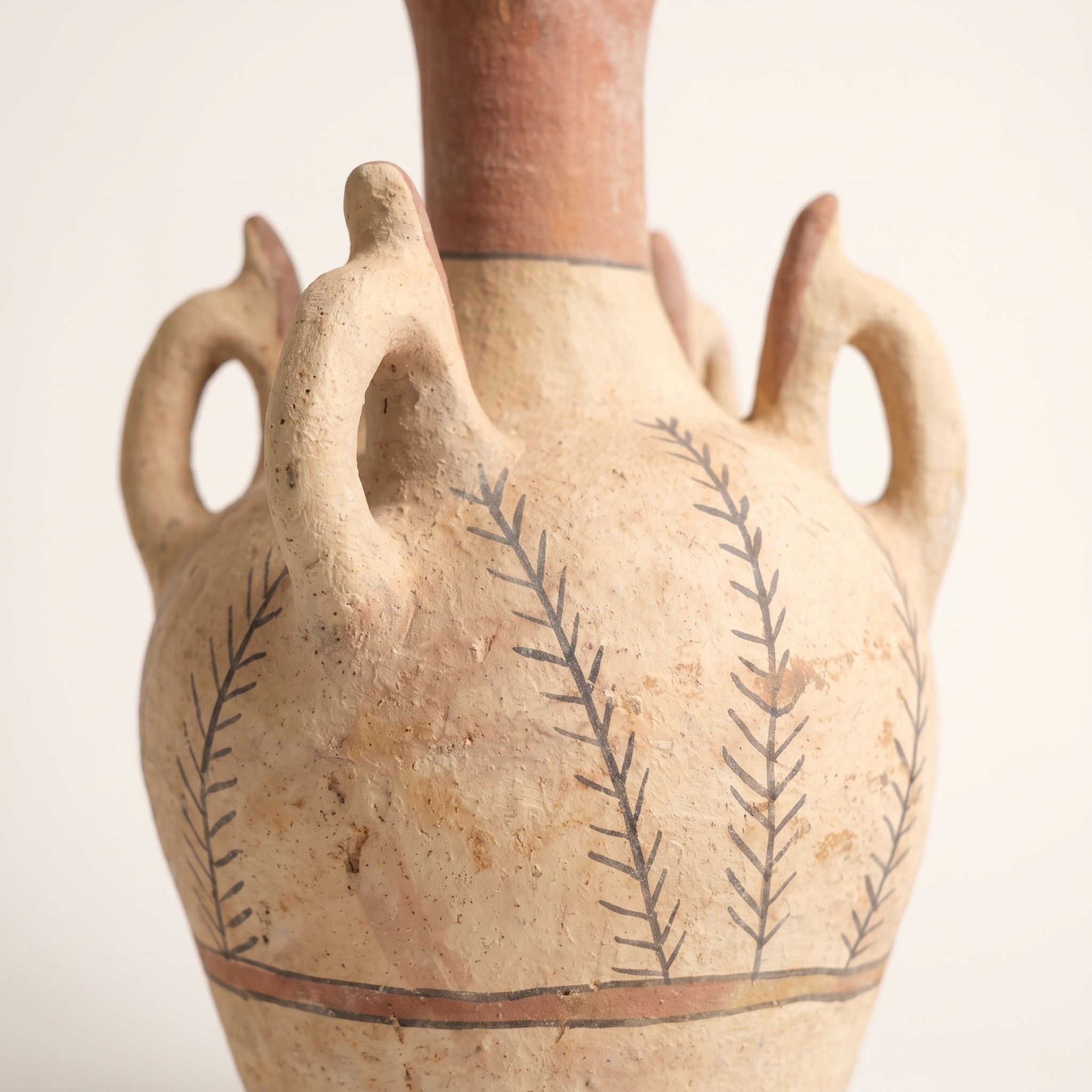 Detailed view of the textured ceramic surface and hand-drawn leaf motifs