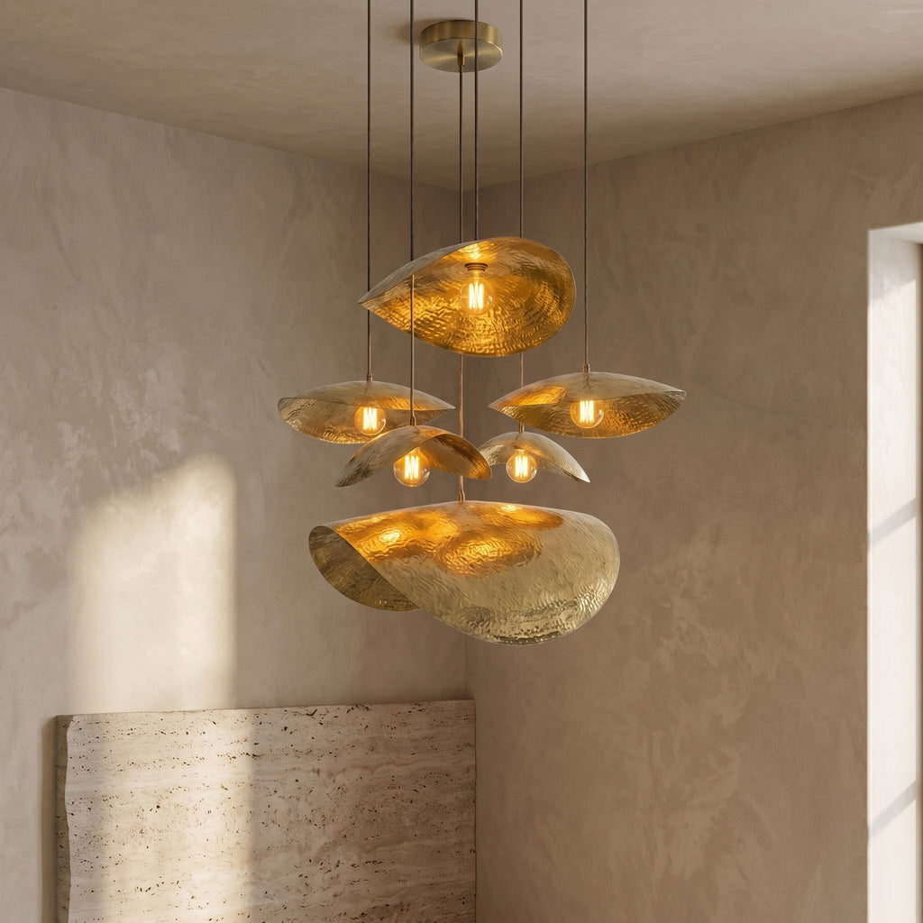 Lit multi-pendant brass chandelier suspended at varied heights