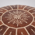 Detail of the stitched star motif on a brown Moroccan leather pouf