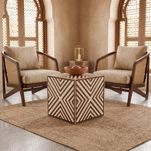 Brown and cream chevron-inlay cube side table with a tea set between armchairs