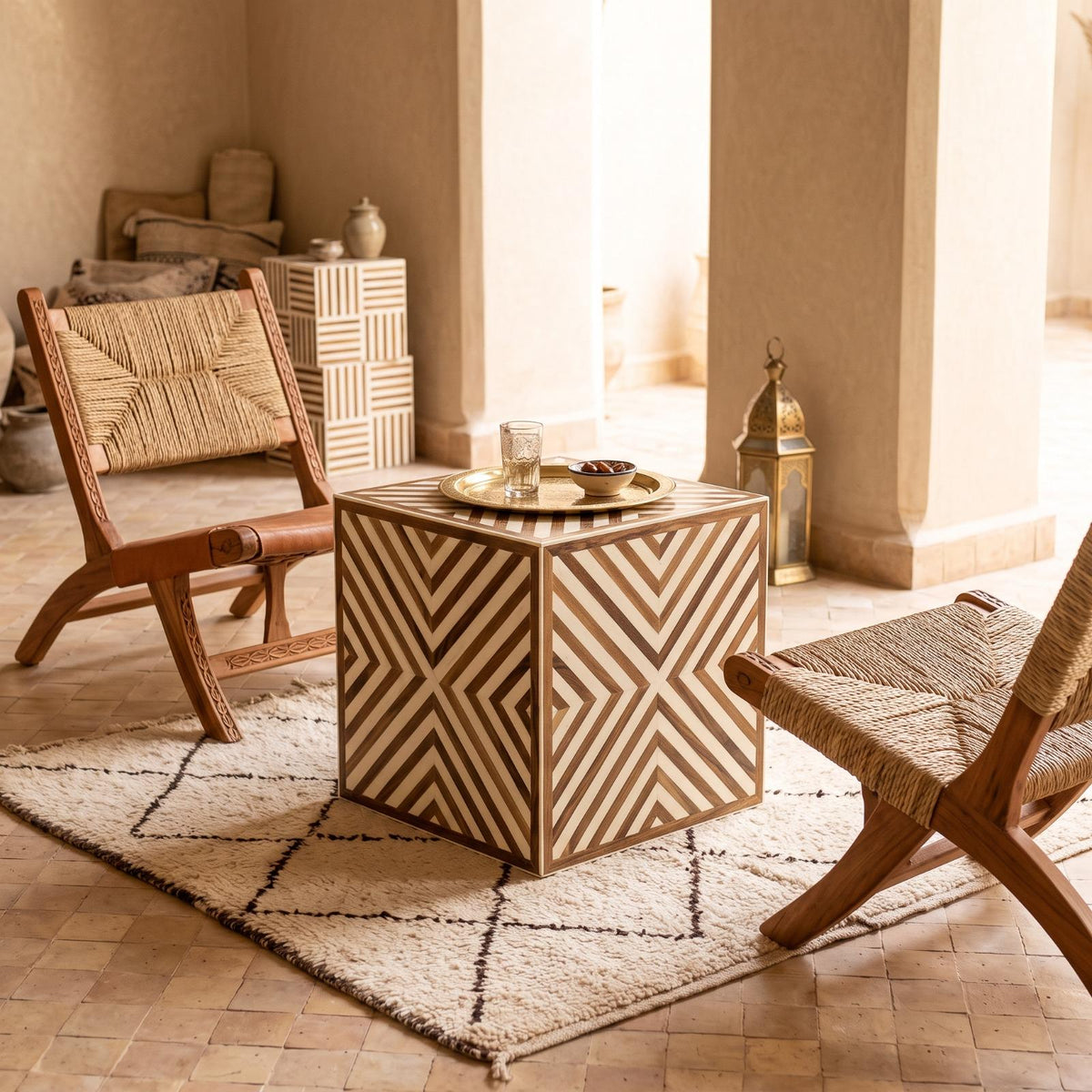 Chevron wood-inlay cube table with a brass tea tray in a bright beige seating area