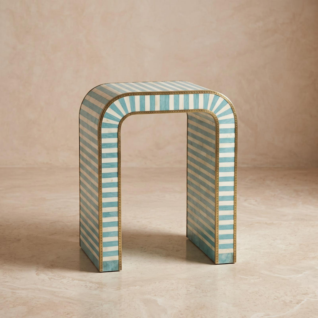Angled view of a turquoise striped arch table showing its open center and patterned sides