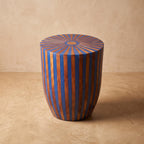 Blue and orange wood-inlay drum side table with a radial sunburst top