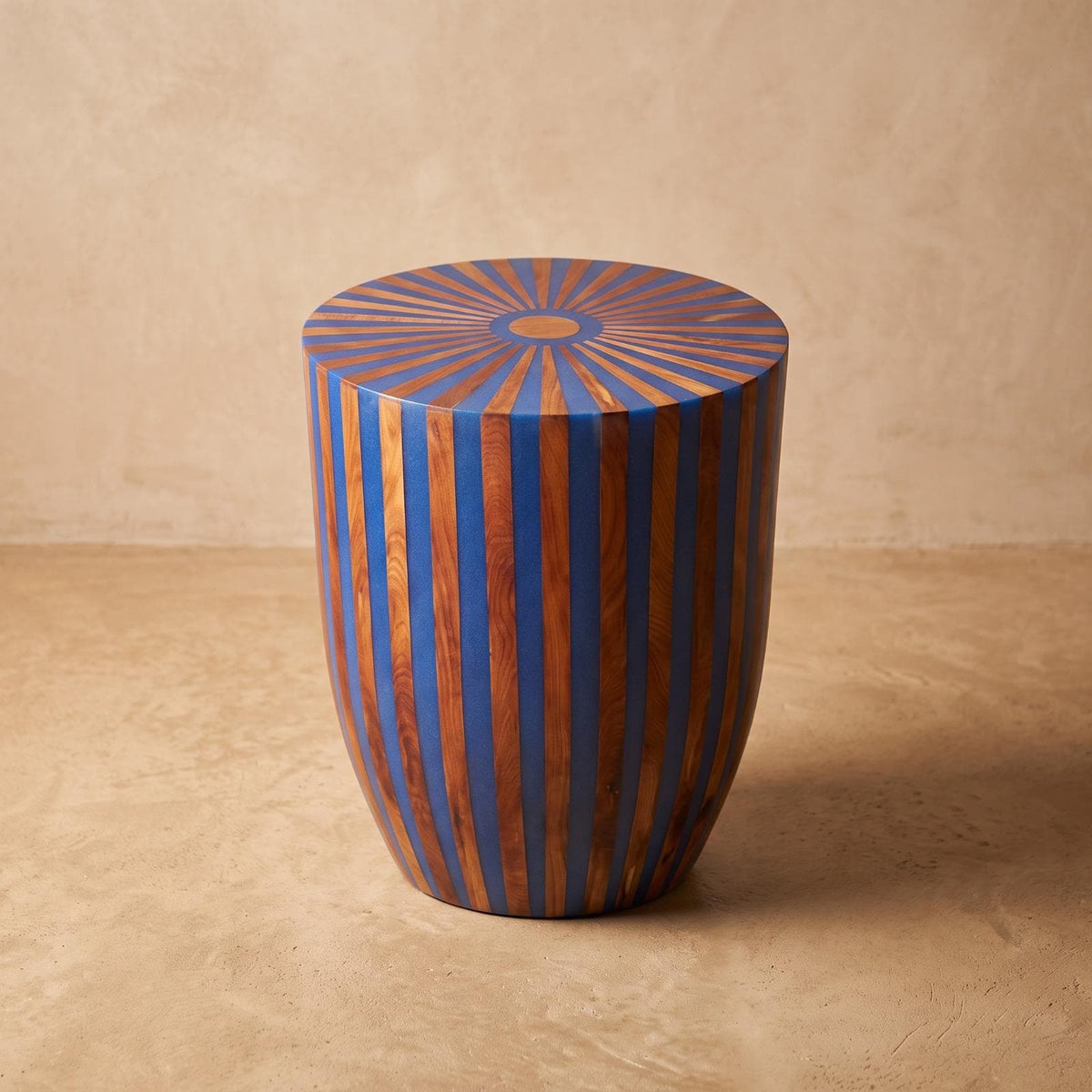 Blue and orange wood-inlay drum side table with a radial sunburst top
