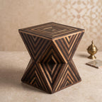 Angled view of a dark wooden hourglass table showing chevron inlay and its square top