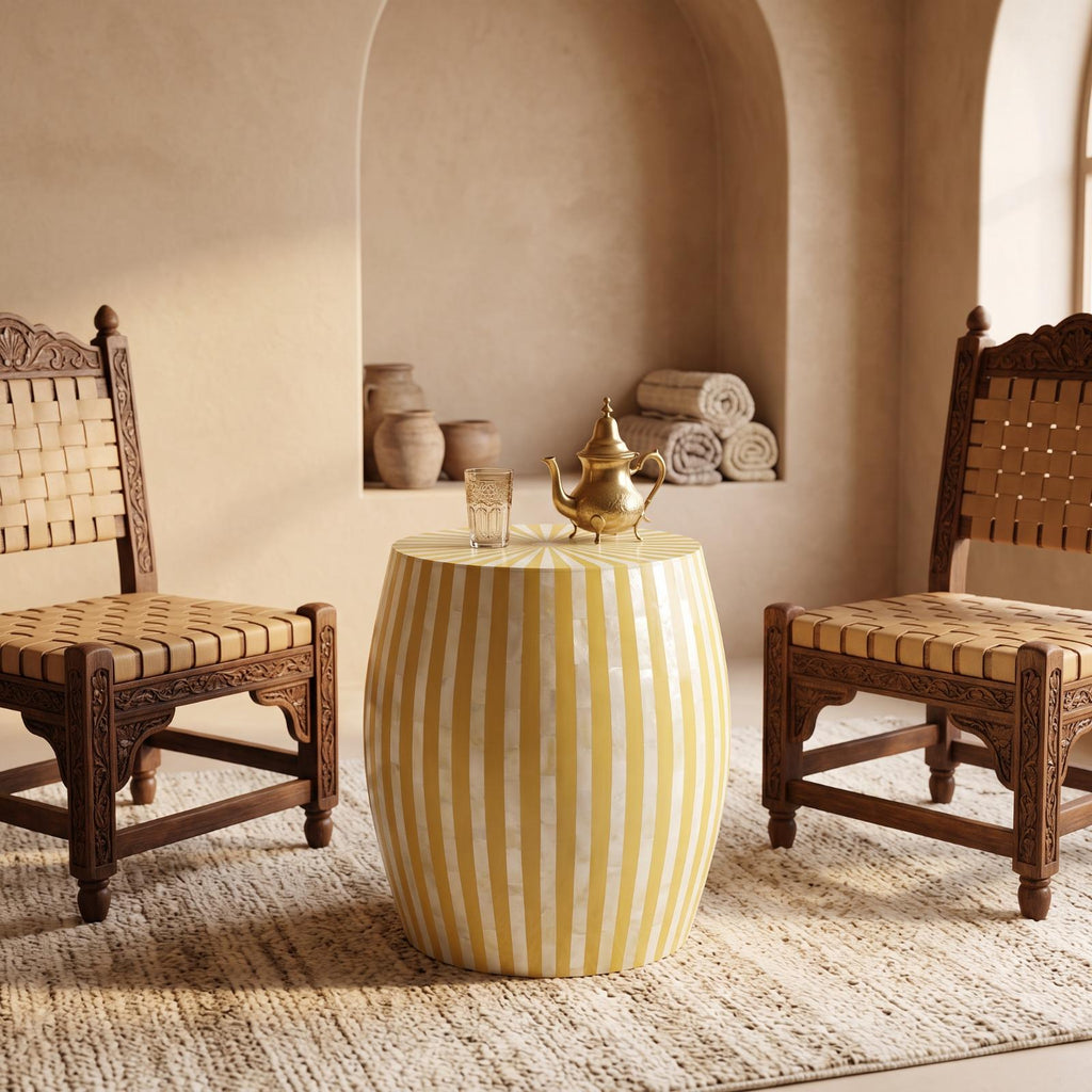 Yellow and cream striped drum table between woven wooden chairs in a beige interior