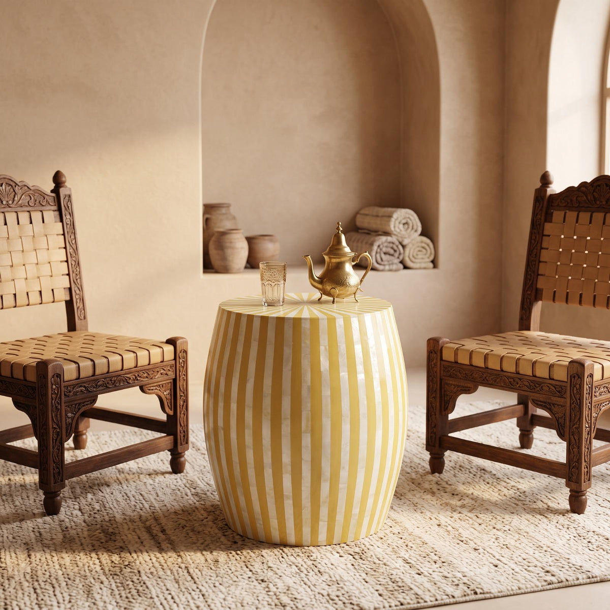 Yellow and cream striped drum table between woven wooden chairs in a beige interior