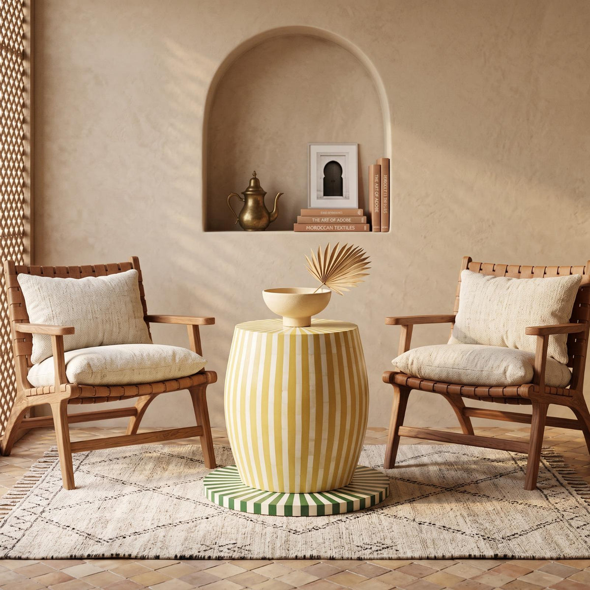 Yellow striped drum side table topped with a bowl between two cushioned chairs