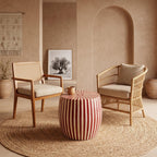 Red striped drum side table with a vase between two armchairs in a beige interior
