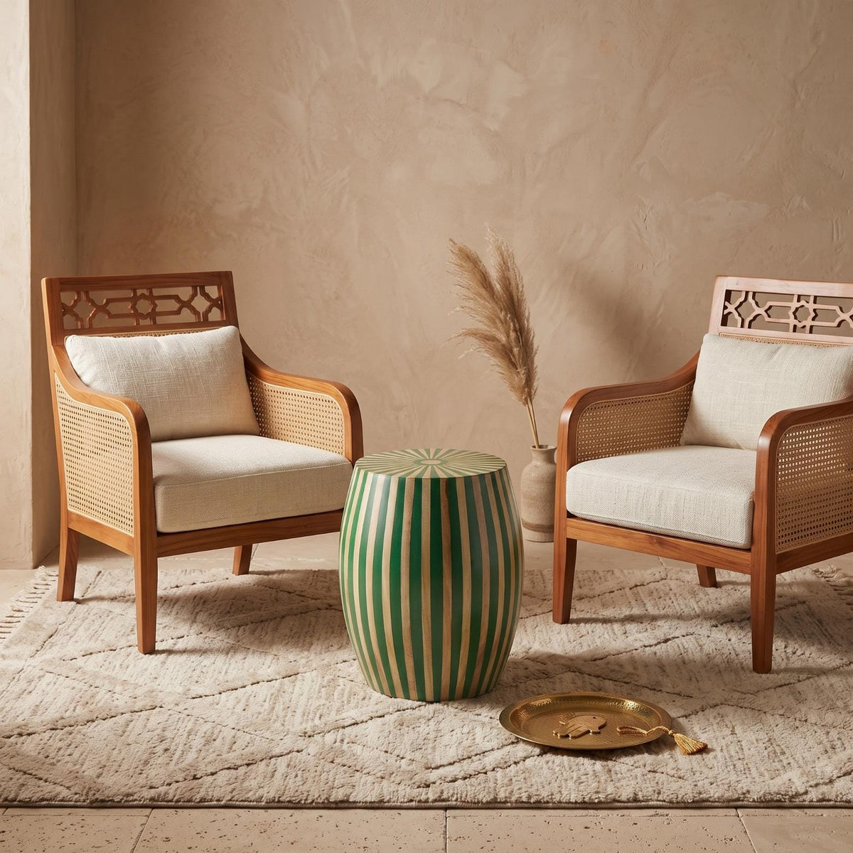 Green striped wooden drum table between two cushioned armchairs on a woven rug