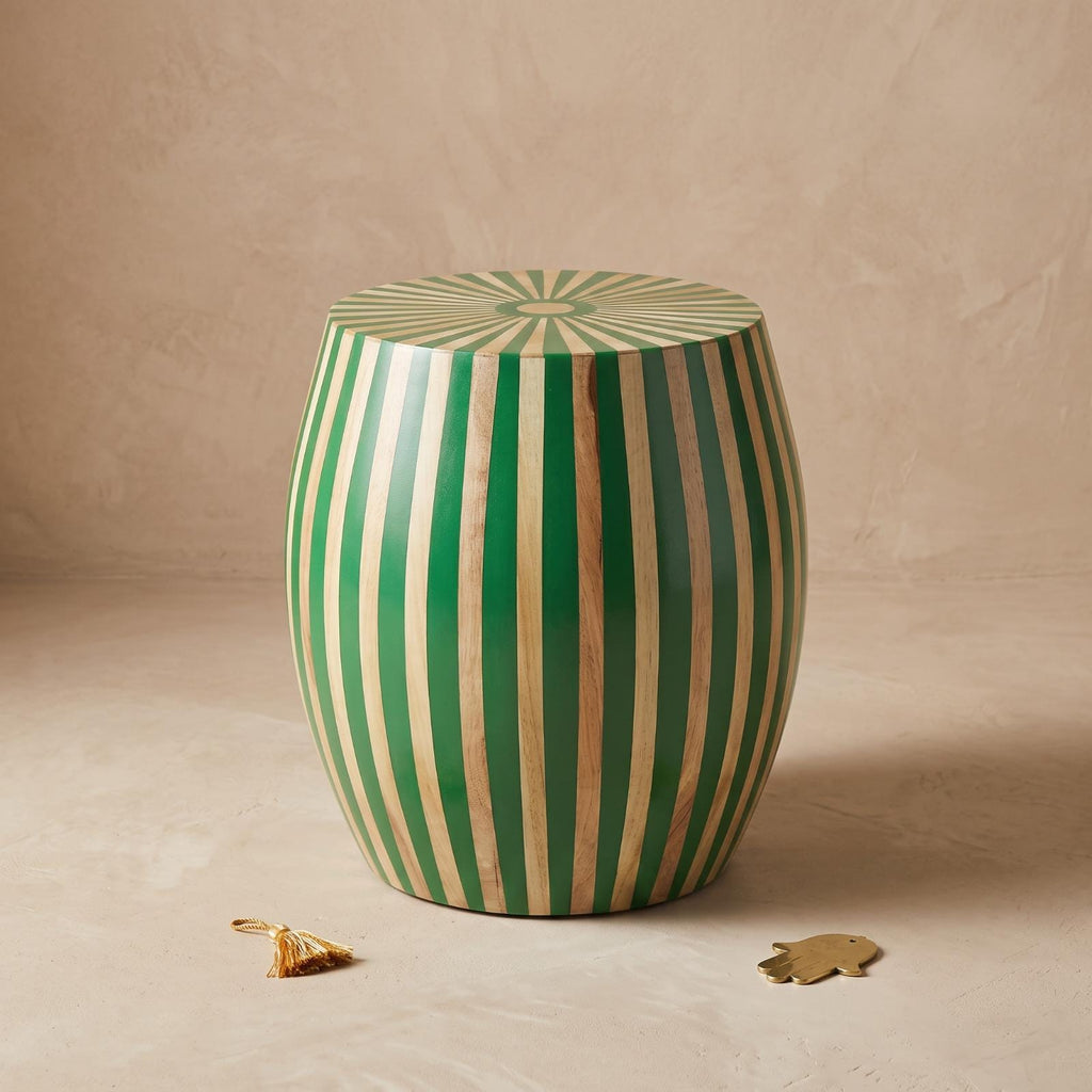 Angled view of a green and natural wood striped drum table with a sunburst top