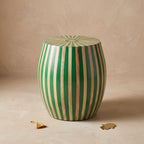 Angled view of a green and natural wood striped drum table with a sunburst top
