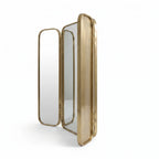 Side view of Moroccan brass triptych mirror with folding panels partly open against a white background