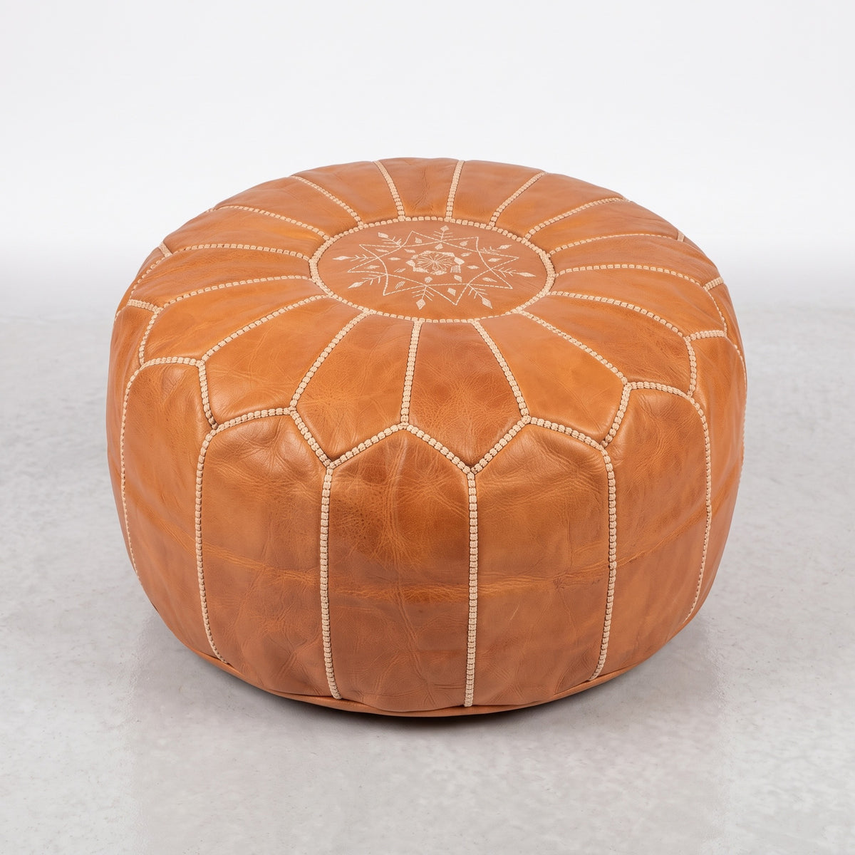 Handmade Moroccan leather pouf in caramel tan with traditional stitching