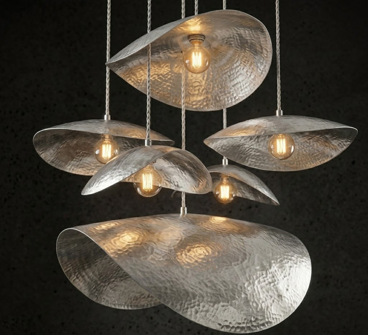 Silver finish hammered petal pendant lights with warm bulbs in a multi-pendant arrangement