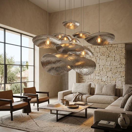 Silver petal pendant above a coffee table in a stone-walled living room
