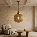 Brass Spiral Bands pendant above a round coffee table beside a cream armchair