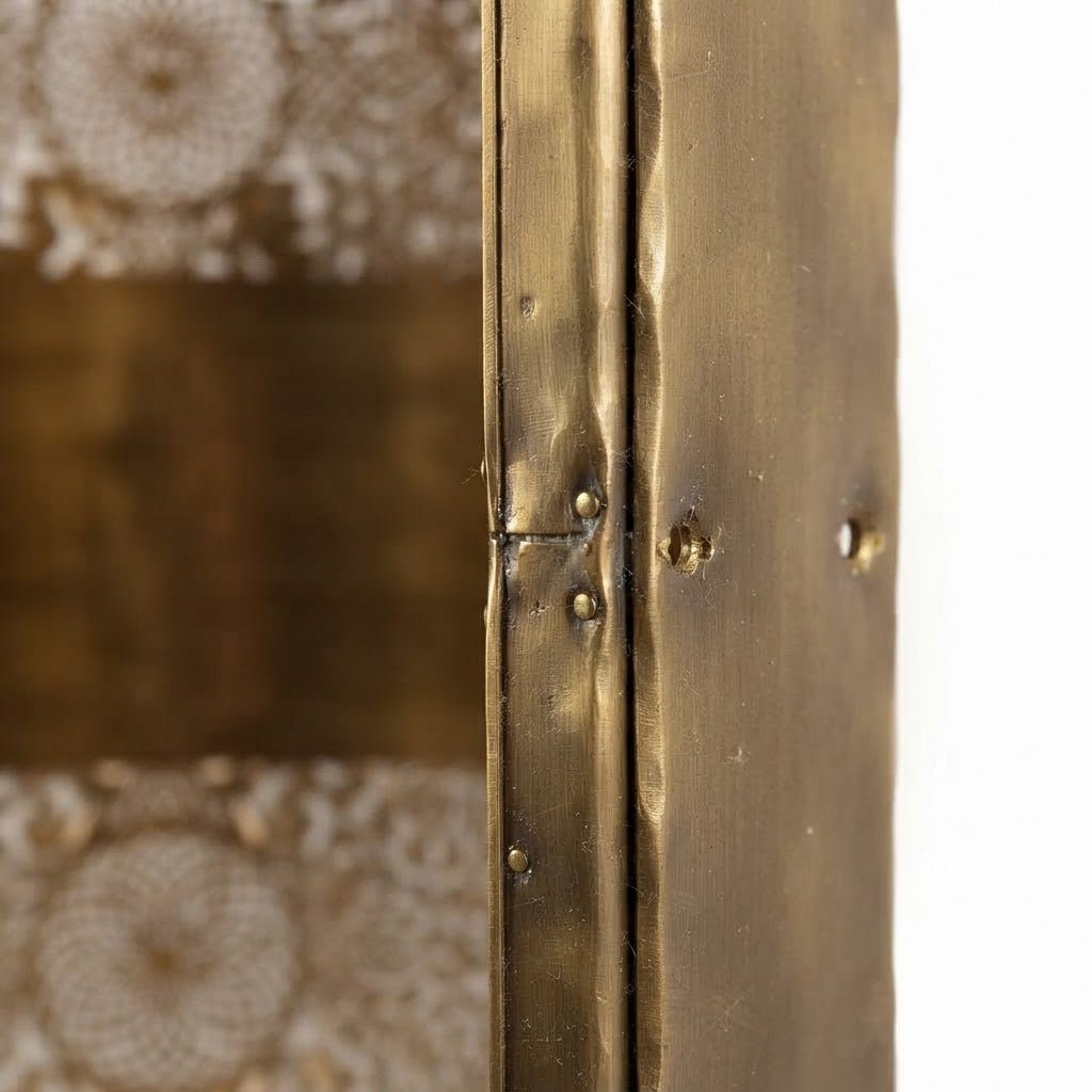 Close-up of the seam and smooth central band on a twin rosette brass wall sconce