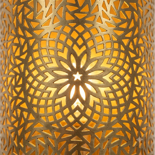 Close-up of a Moroccan brass wall sconce with pierced floral rosette and geometric patterns