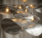 Close view of the textured silver petals and warm bulbs of a sculptural pendant