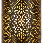 Close-up of an illuminated arabesque medallion on a dark brass wall sconce