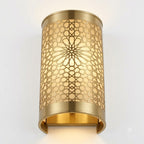 Angled view of an illuminated brass rosette wall sconce showing its open lower edge