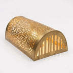 Angled view of a curved Moroccan brass wall sconce showing its open end and pierced metal