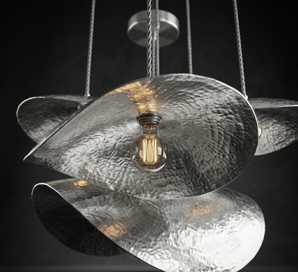 Silver hammered petal pendant with overlapping curved shades and a glowing bulb