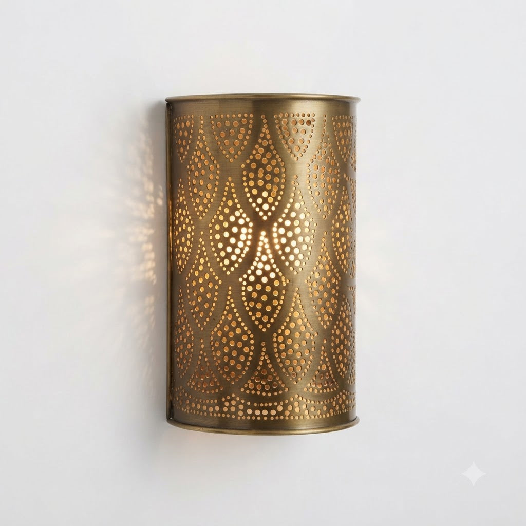 Curved brass wall sconce with repeating pierced teardrop motifs