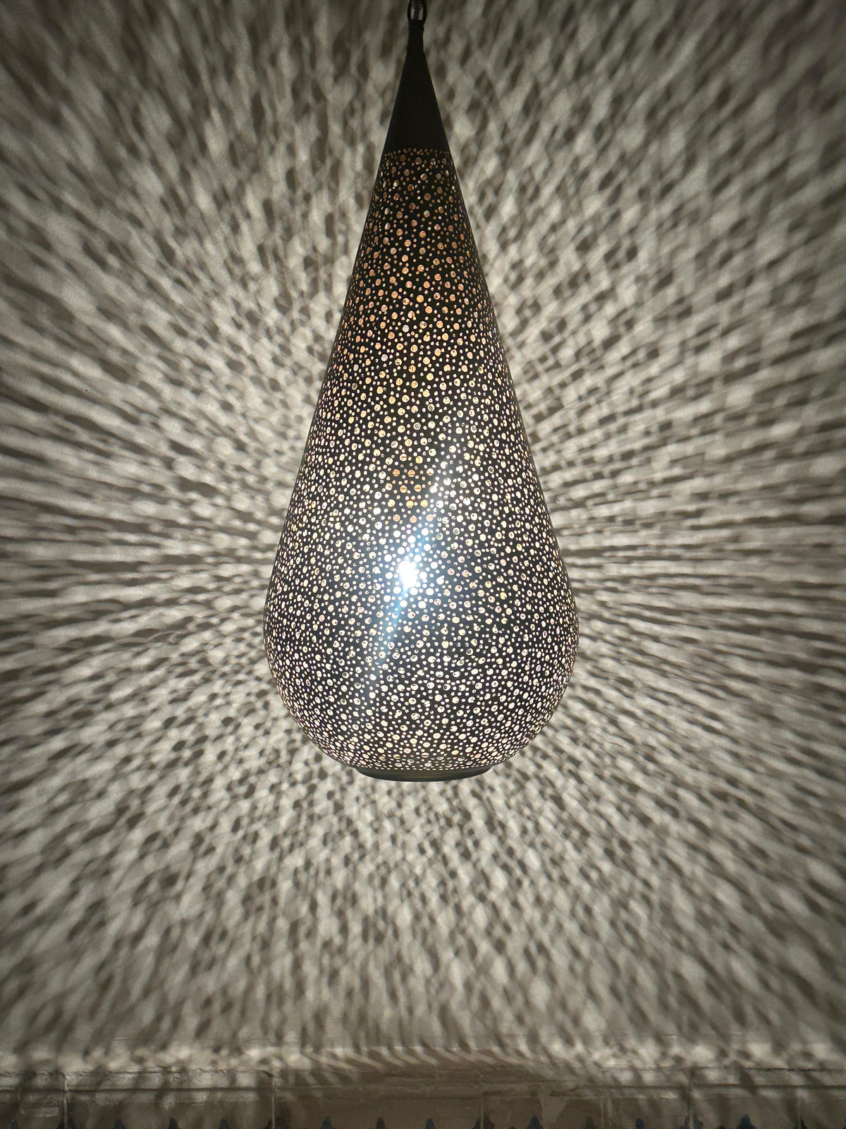 Moroccan Perforated Teardrop Pendant with a perforated brass teardrop silhouette