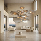 Large silver petal pendant above a coffee table in a bright living room