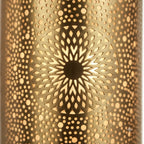 Close-up of an illuminated sunflower medallion and tiny perforations in a brass wall sconce