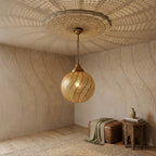 Spiral Bands brass globe pendant beside a bench in a softly lit room