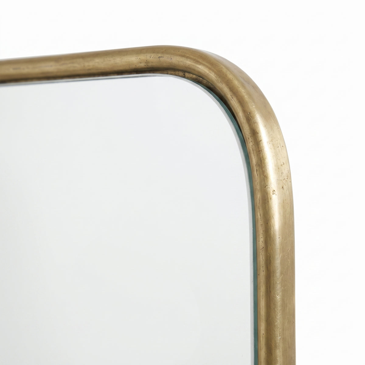 Close-up of the rounded corner and textured brass frame of the Moroccan triptych wall mirror