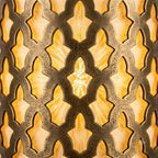 Close-up of interlocking lattice cutouts in a Moroccan brass wall sconce