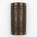 Front view of a curved dark brass wall sconce with a pierced starburst design